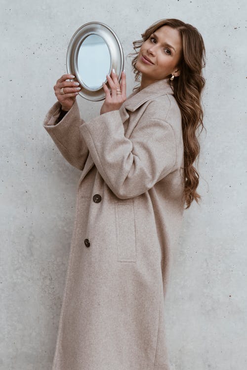 A woman is holding a mirror in front of her