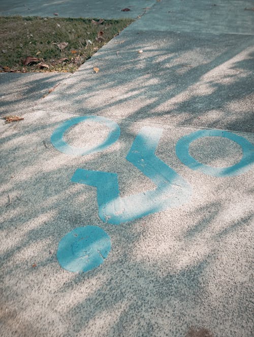 A blue circle painted on the sidewalk with the word o