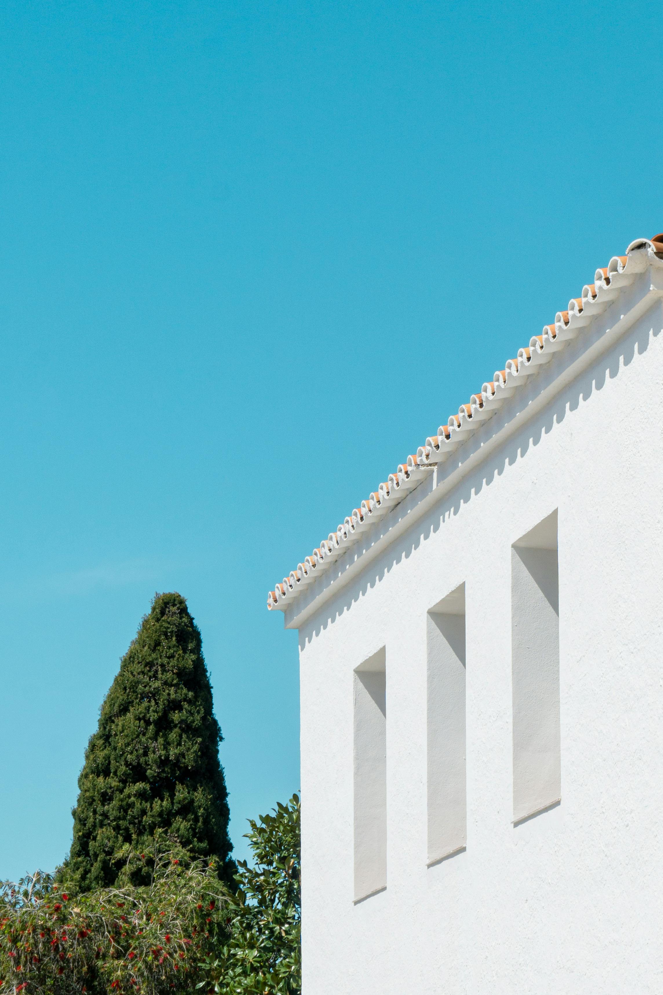 Bright minimalist shot of Mediterranean architecture in Nerja, Spain with clear blue sky.