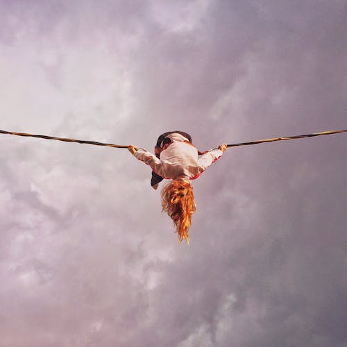 Girl With Orange Hair Flipping While Holding Rope