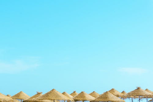 Beach with umbrellas and chairs under blue sky