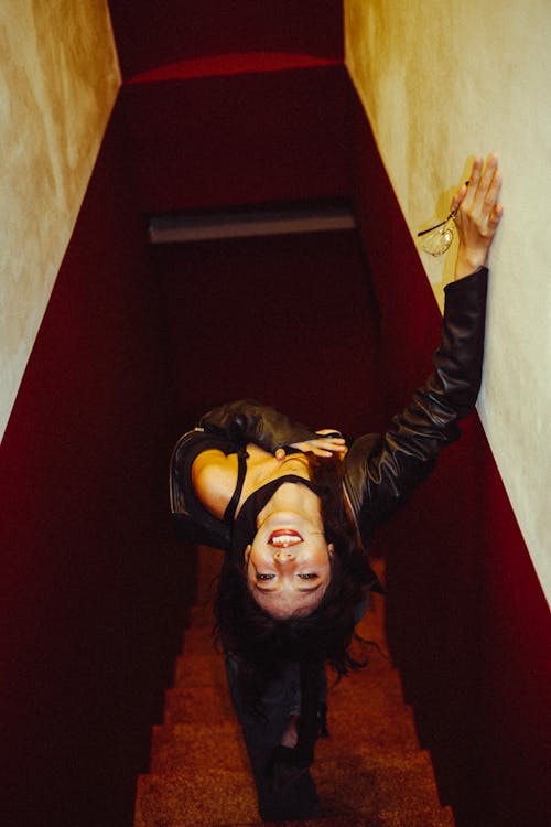 A woman leaning over a stairway with her arms outstretched