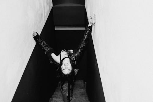 Black and White Photo of a Young Woman Walking Down the Stairs 