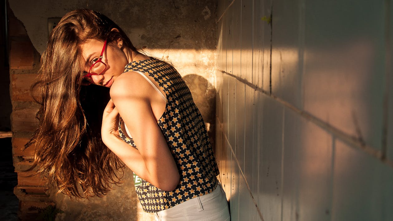 Photo of Woman Standing and Leaning Against the Wall