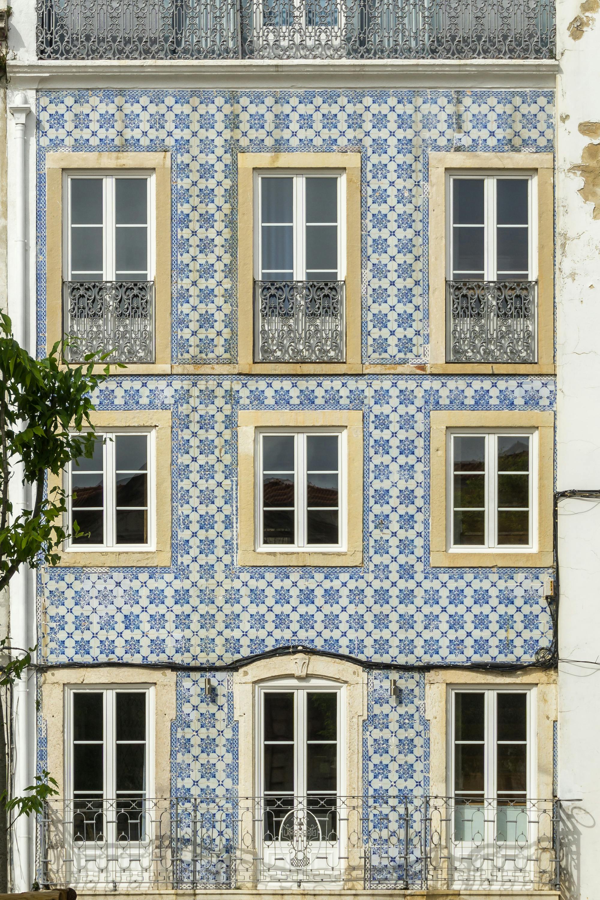 Detailed view of a traditional blue-tiled building facade in Lisbon, Portugal.