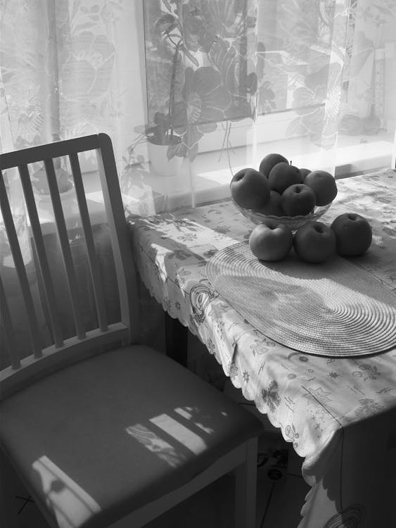 A black and white photo of a table with apples on it