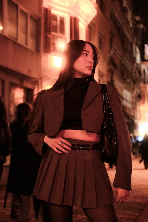 Brunette Woman in Suit Jacket and Skirt at Night