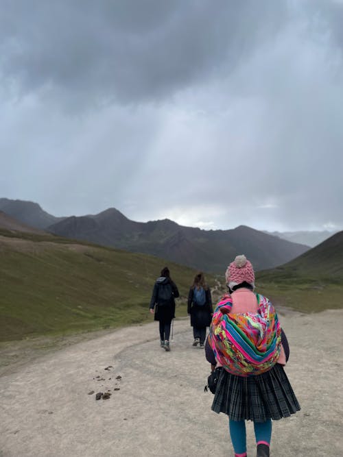 A group of people walking down a dirt road