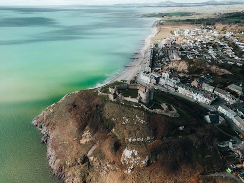 Aerial view of the coast and castle in a green field