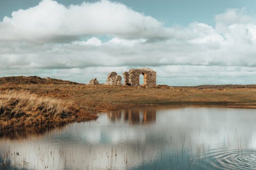 A photo of a pond and a stone building