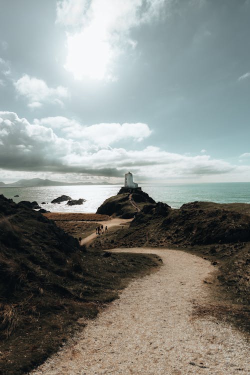 A path leading to a lighthouse on a beach
