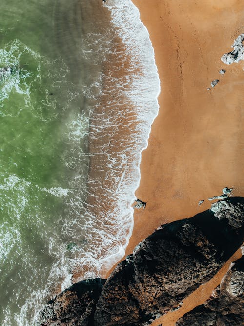 An aerial view of a beach with waves