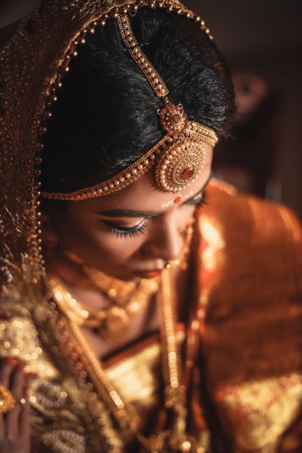 Portrait of a South Asian bride in traditional attire with ornate jewelry and intricate makeup.