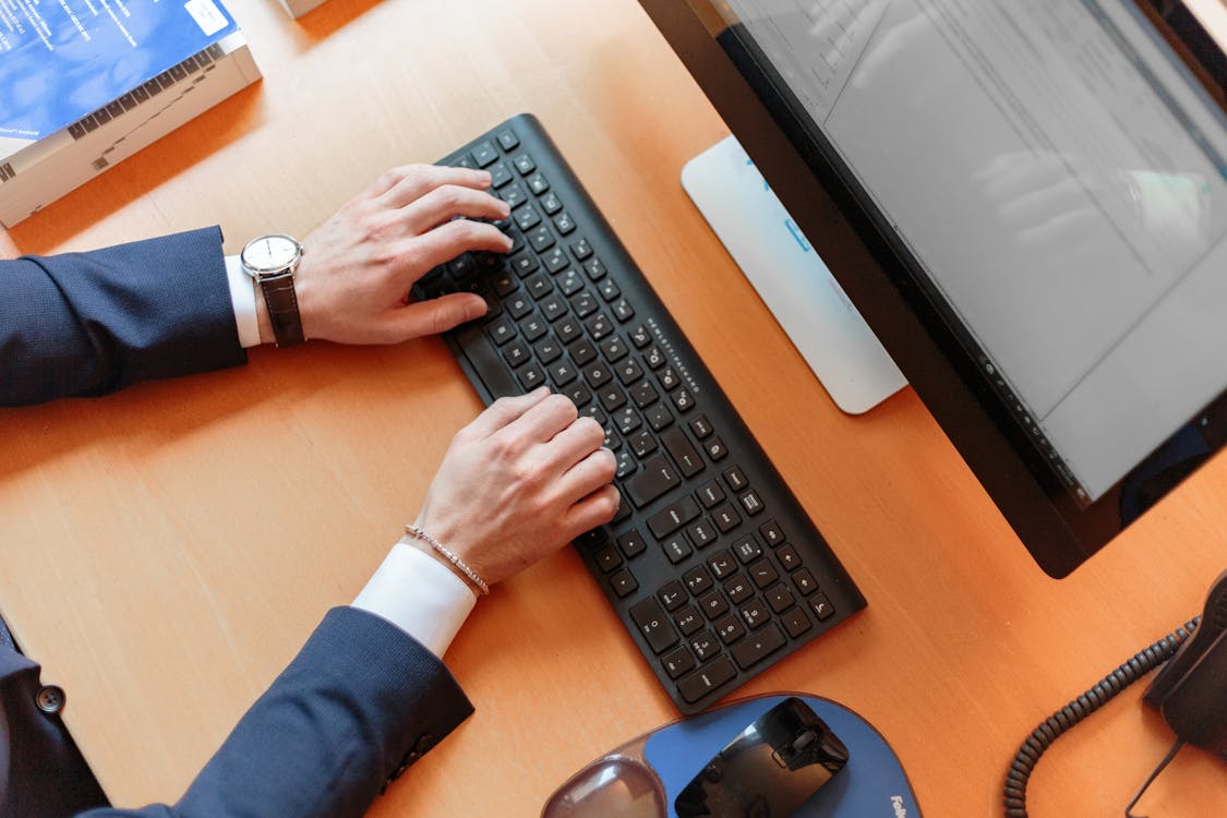 Persona escribiendo en el teclado de la computadora