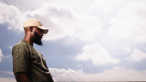 Bearded Man Standing against the Clouds