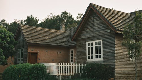 A small wooden house with a white picket fence