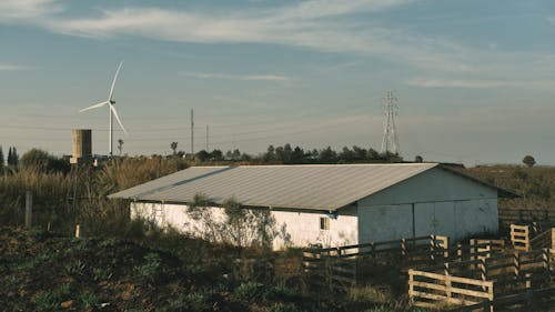 A barn with a windmill in the background