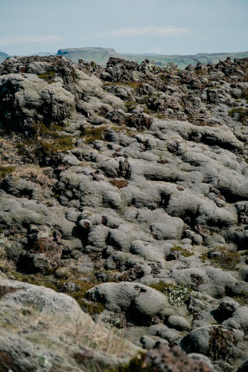 A man is standing on top of a rocky hill