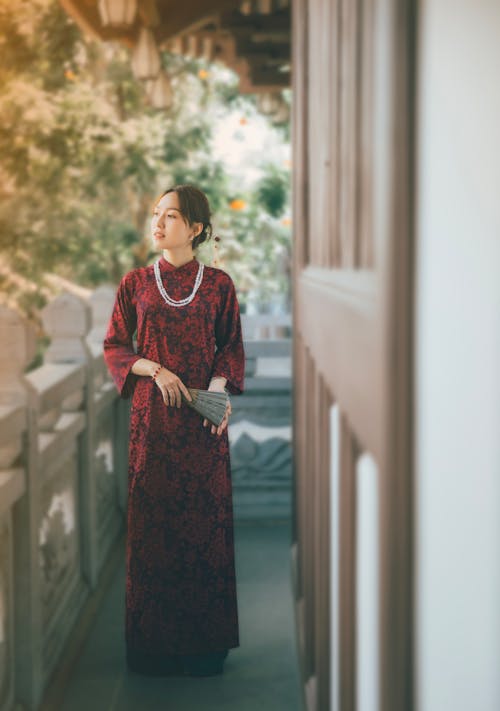 A woman in a red dress standing on a balcony