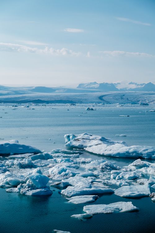 Free Beautiful frozen icebergs float on a serene lake under a clear winter sky. Stock Photo