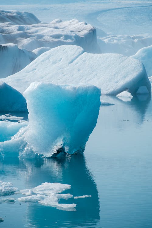 Blueish Icebergs Melting in Water