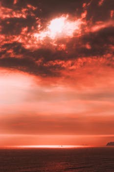 Beautiful and dramatic red sunset over the ocean in Lima, Peru, showcasing vibrant colors and a serene coastal view.