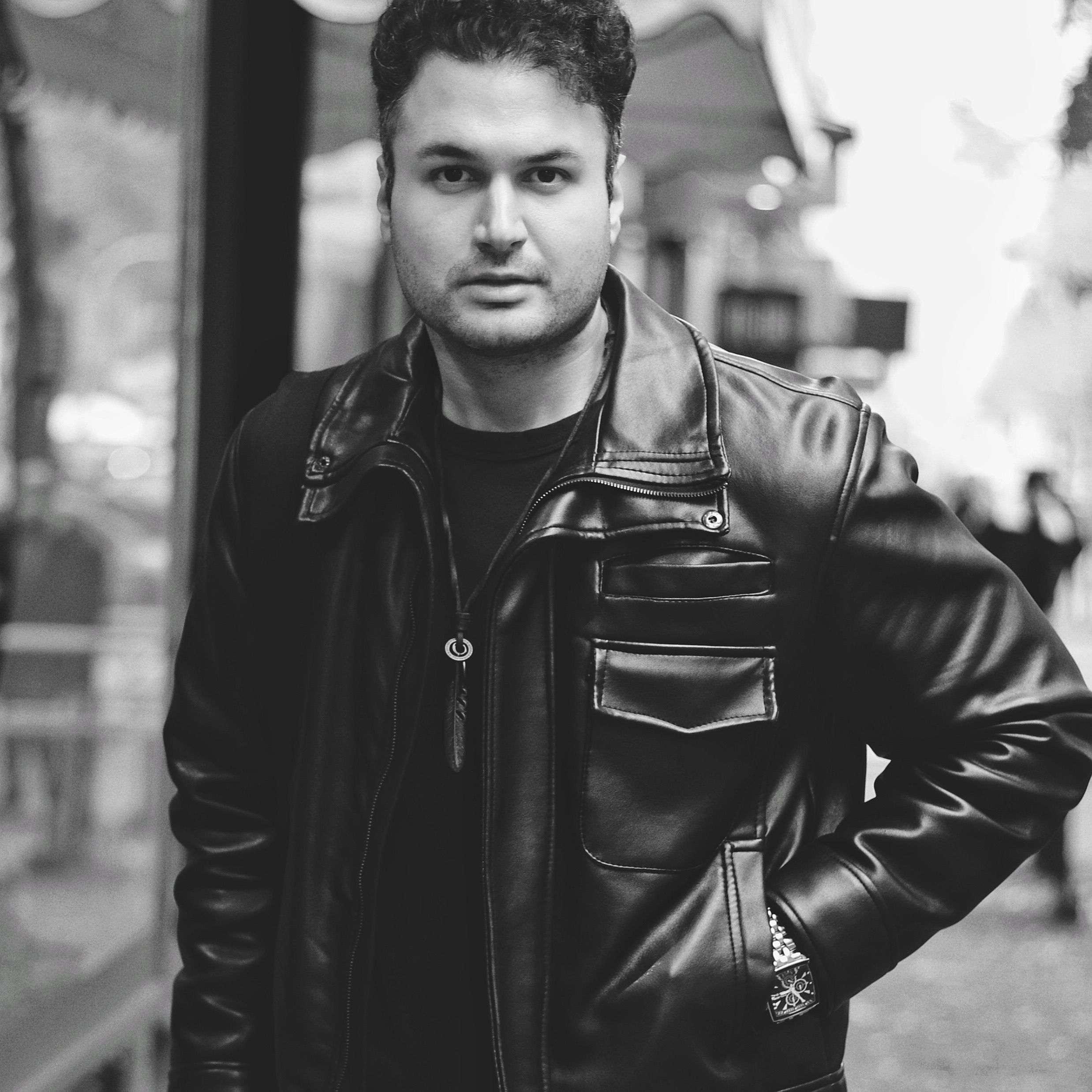 Black and white portrait of a man in leather jacket on Frankfurt street.