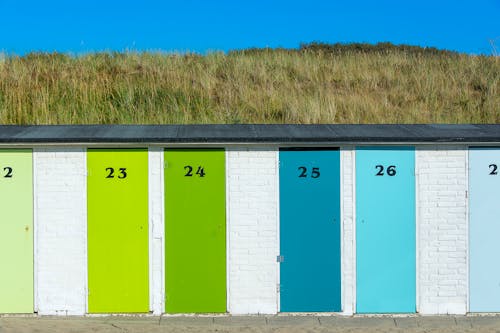 A row of brightly colored beach huts with numbers on them