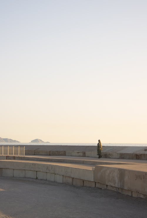 A person is walking on a concrete walkway