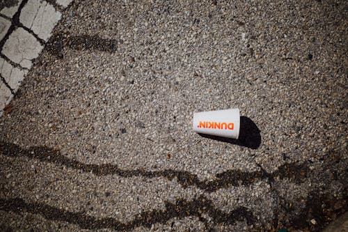 A white and orange can on the ground