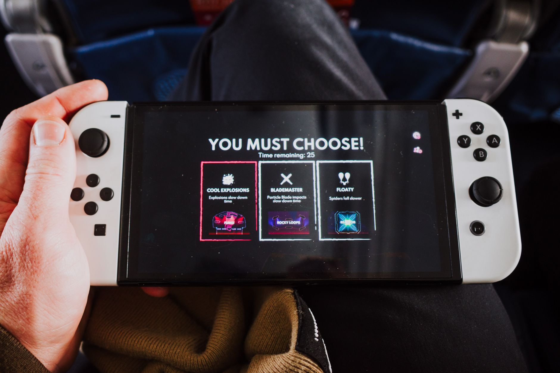 Close-up of a person holding a gaming console with an on-screen decision prompt.