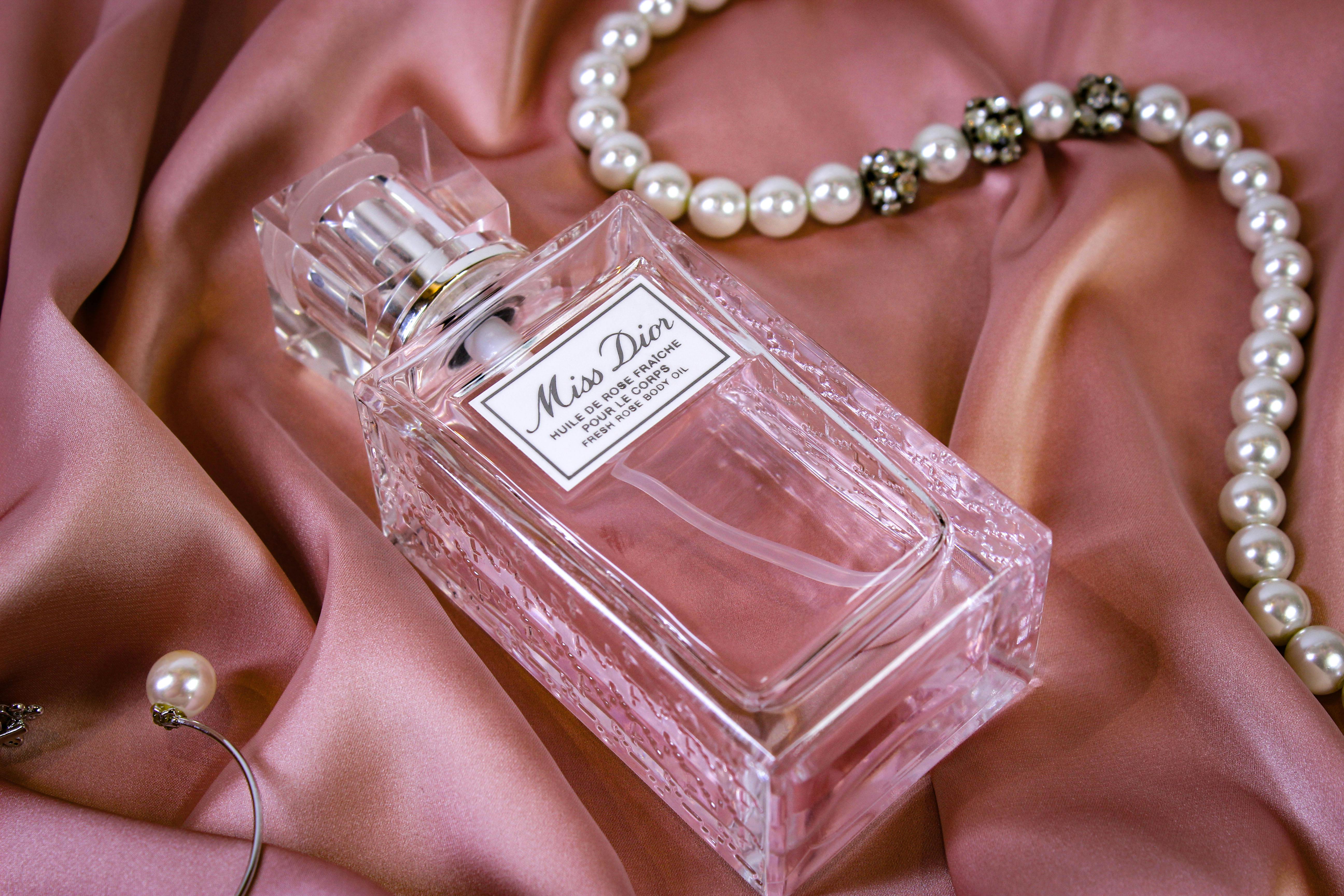 İpek bir kumaş üzerindeki parfüm lekesi ve hassas kıyafet temizliği sürecini temsil eden bir görsel.