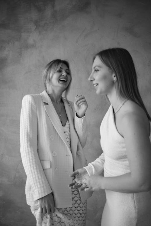 Two women laughing together in a black and white photo