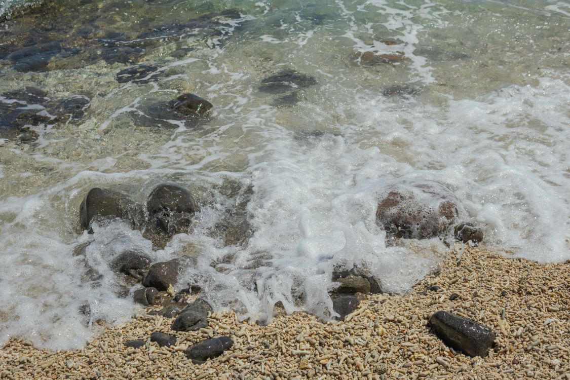 A beach with rocks and water · Free Stock Photo