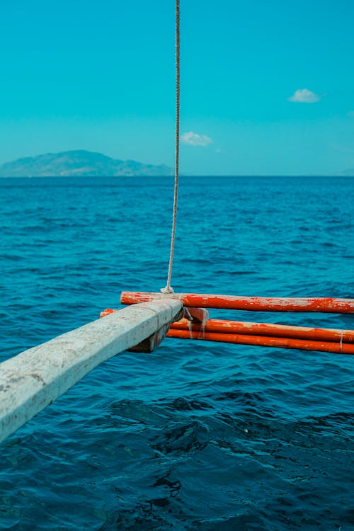 A red and white pole in the ocean with a rope attached