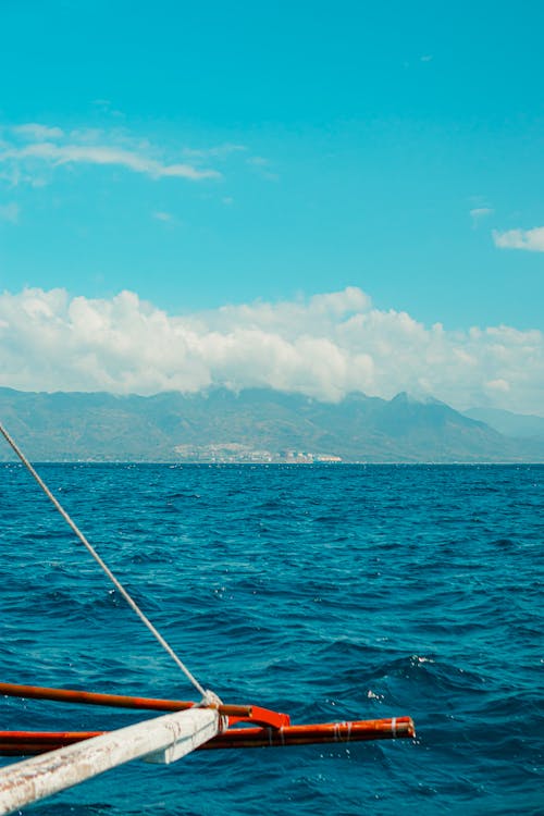 A boat in the ocean with mountains in the background
