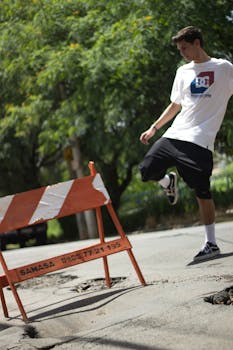 穿着休闲装的年轻人在阳光明媚的城市街道旁，与护栏嬉戏互动