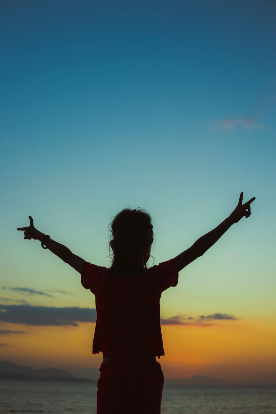 Silhouette of a person raising both arms against a sunrise sky — photo by Nothing Ahead on Pexels