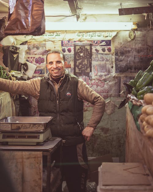 A man standing in a market with vegetables