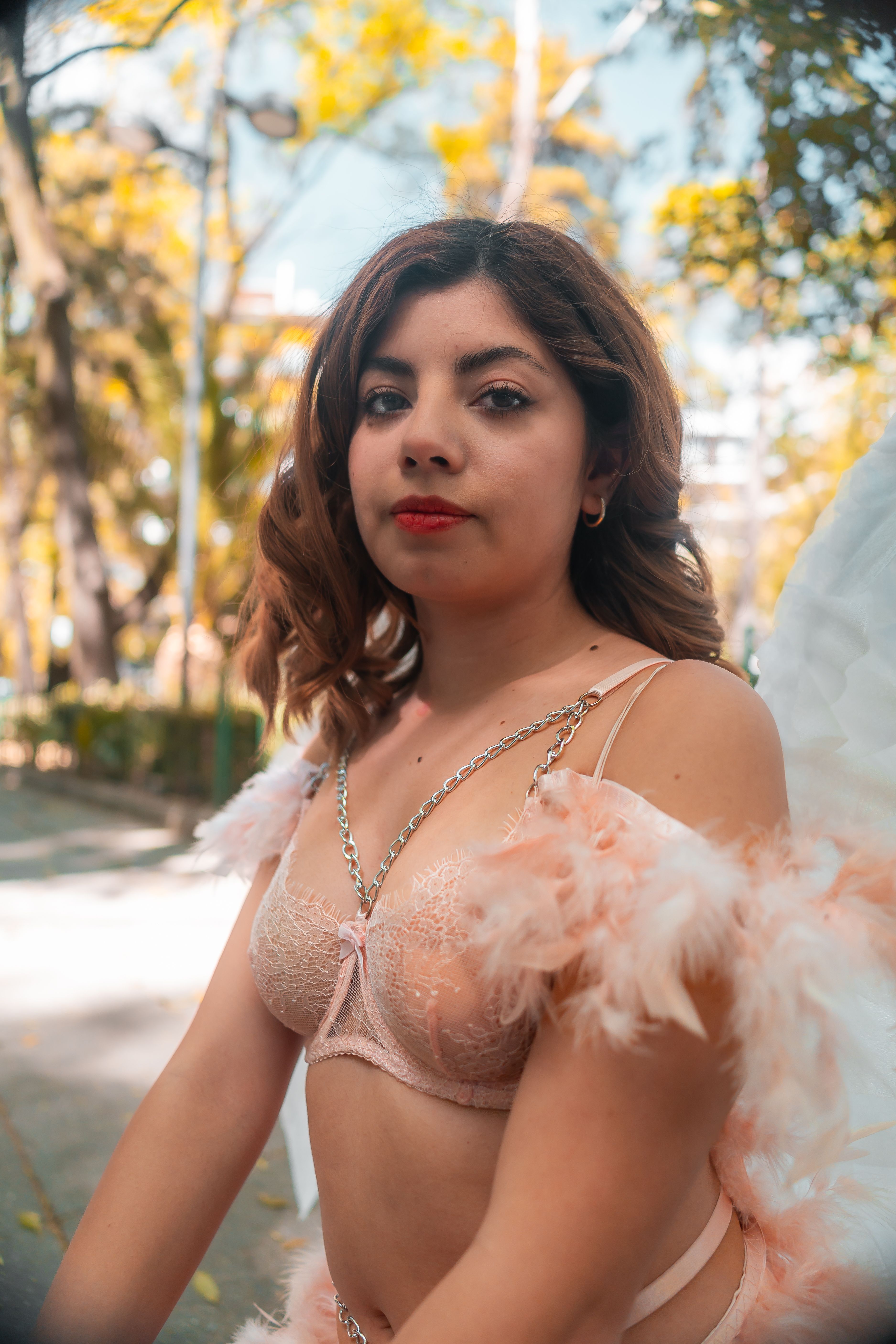 A captivating portrait of a woman with angel wings in a city park setting.