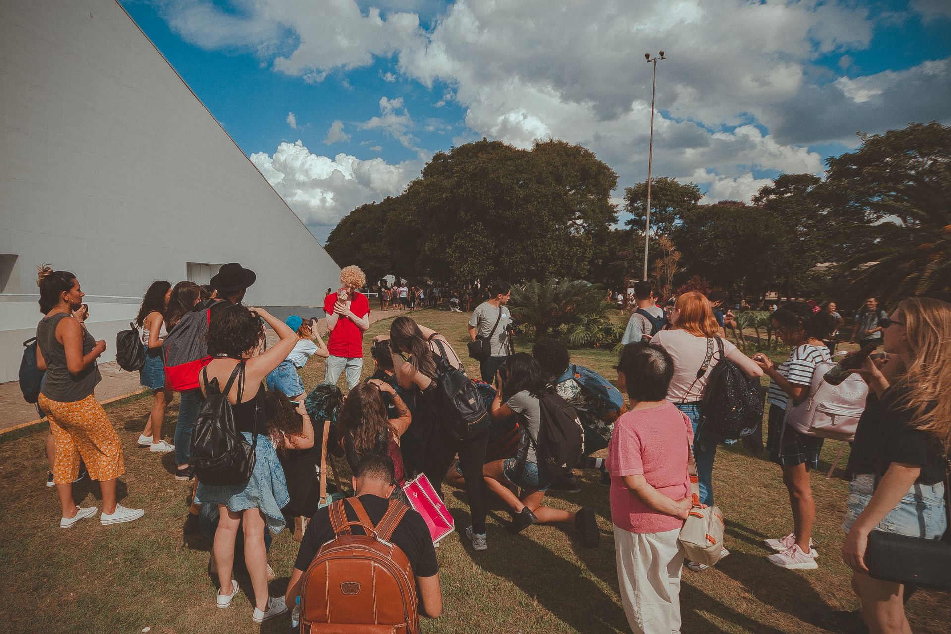 A lively group of diverse people gathered in an outdoor area, enjoying a sunny day.