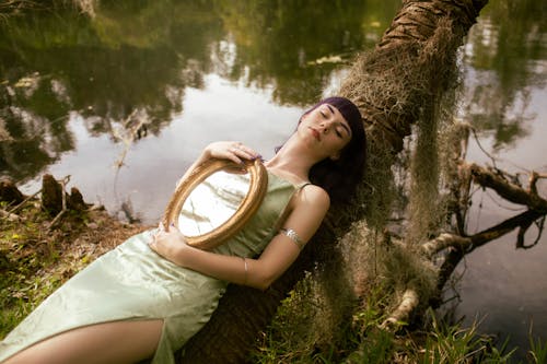 Woman with Mirror Lying Down on Tree