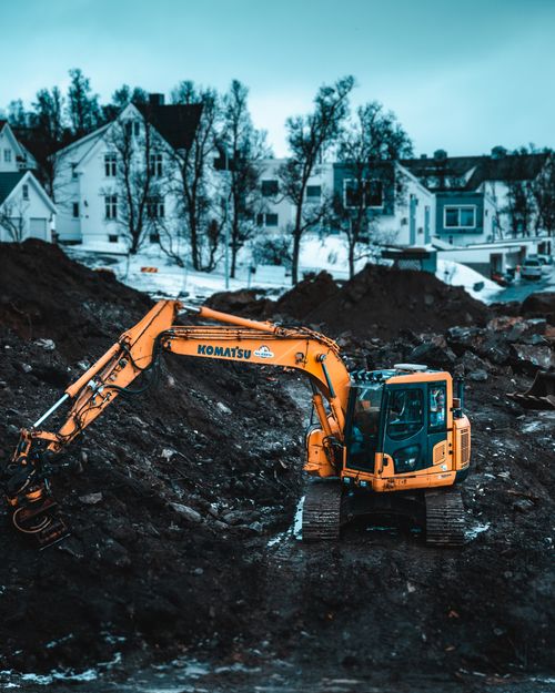 Free A powerful excavator operates at a Tromsø construction site during winter, showcasing heavy machinery. Stock Photo