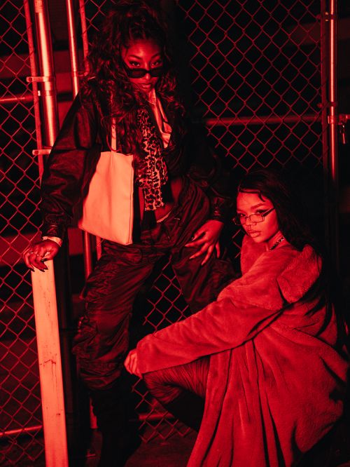 Free Edgy nighttime portrait of fashionable models posing with bold red lighting. Stock Photo