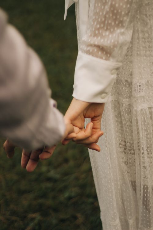 Free Close-up of a couple holding hands in wedding attire, emphasizing romantic connection. Stock Photo