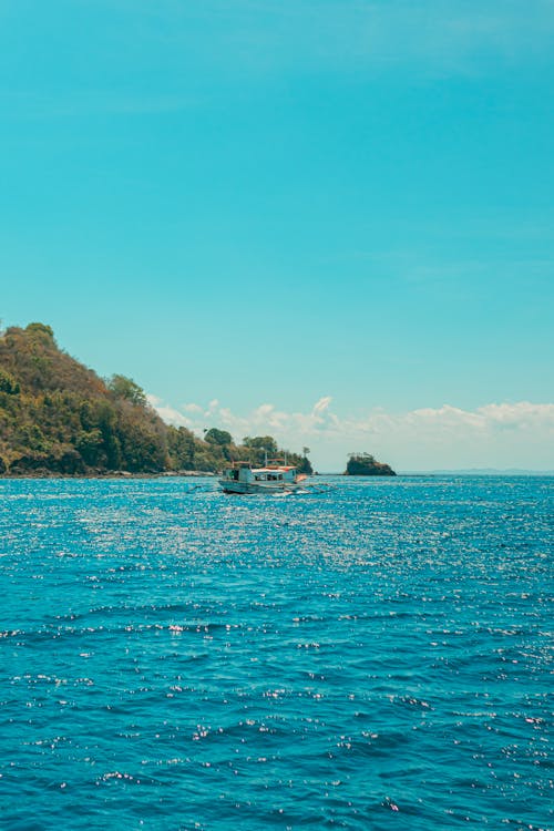 A boat in the ocean with a small island in the background