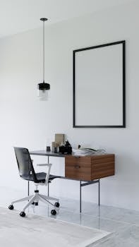 Stylish minimalist office setup with desk, chair, and framed artwork in bright space.