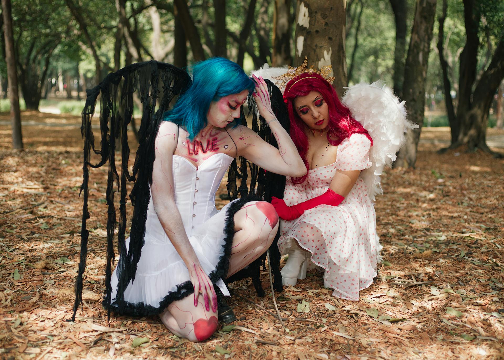 Women in Angels Costumes Crouching in Forest