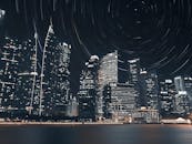 长时间曝光下的新加坡夜间天际线令人惊叹，突出了摩天大楼与星光轨迹