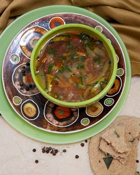 Top view of a warm homemade vegetable soup served in an artistic bowl.